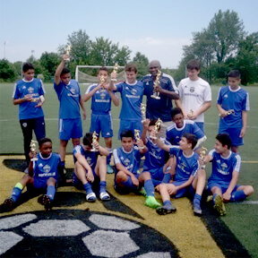 Youth soccer team celebrating with trophies