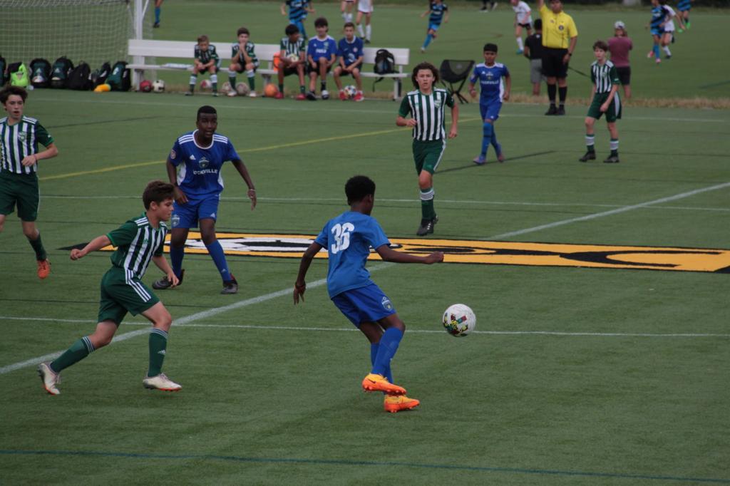 Youth soccer players competing on turf field